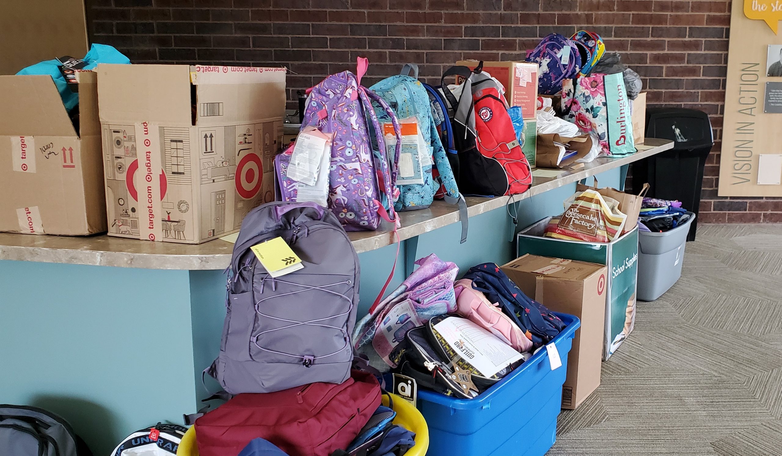 Kids reaching out to help others through a backpack collection